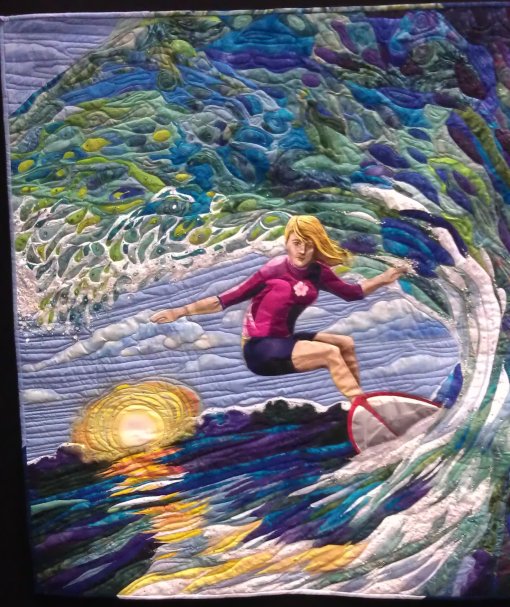 Hang Ten, by Yvonne Chapman. Quilt of a woman surfing a wave at sunset