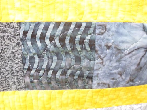 In the panel between the two yellow strips, I stitched a row of elephants