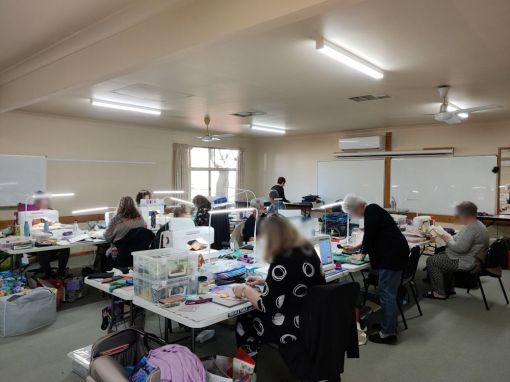 in the large conference room, set up with tables suitable for sewing 