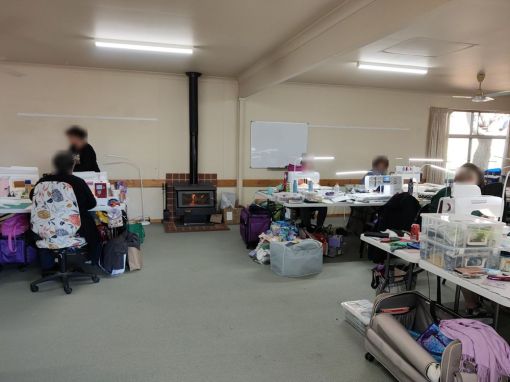 in the large conference room, set up with tables suitable for sewing 